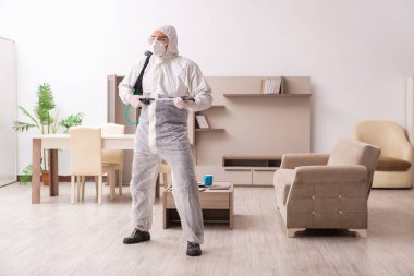 Genç erkek müteahhit evde haşere kontrolü yapıyor.