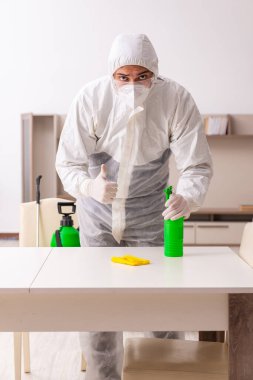 Genç erkek müteahhit evde haşere kontrolü yapıyor.