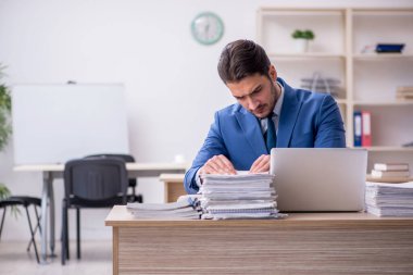 Genç işadamı ve ofiste çok fazla iş var.