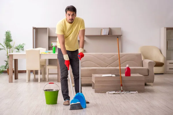 Joven contratista masculino limpiando la casa — Foto de Stock