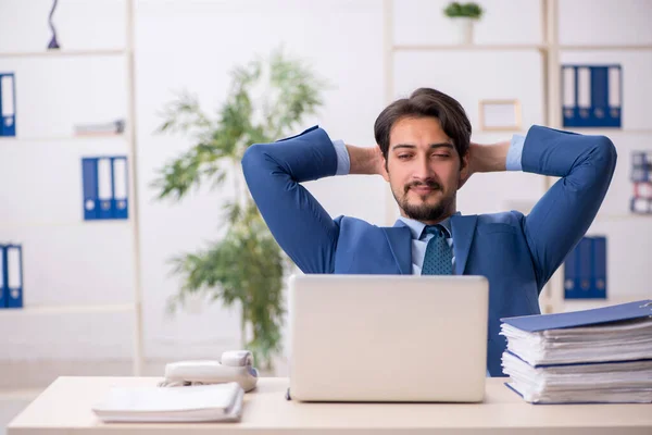 Jovem funcionário masculino e muito trabalho no escritório — Fotografia de Stock