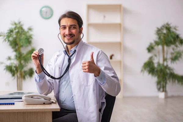 Jonge mannelijke arts werkzaam in de kliniek — Stockfoto