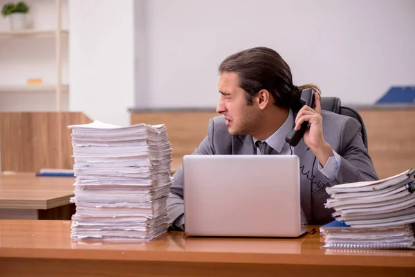 Junge männliche Mitarbeiter und zu viel Arbeit im Büro — Stockfoto