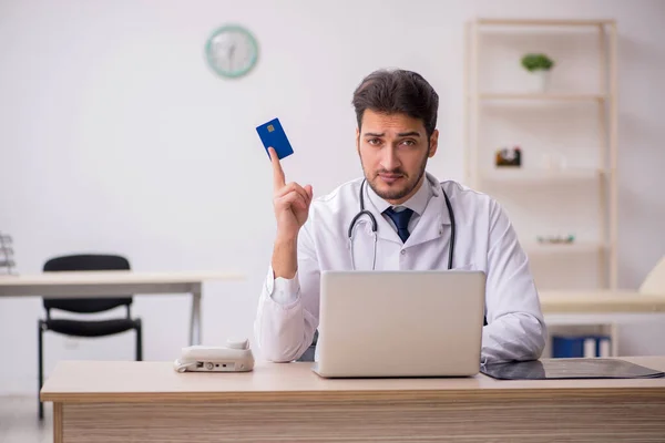 Male doctor holding credit card