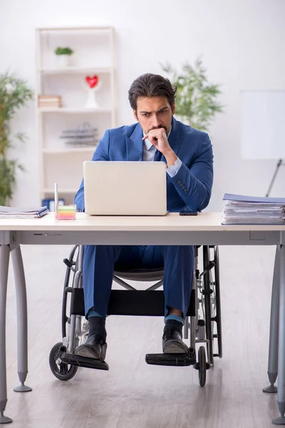 Junge männliche Angestellte im Rollstuhl am Arbeitsplatz — Stockfoto