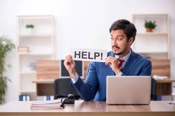 Junge männliche Mitarbeiter sitzen am Arbeitsplatz — Stockfoto