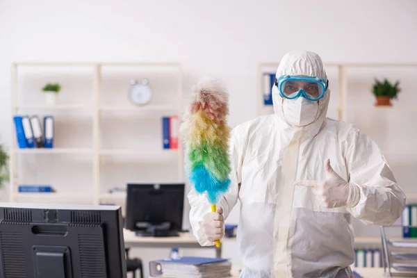 Empreiteiro velho limpando o escritório segurando pena — Fotografia de Stock