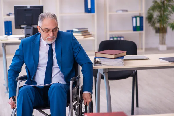 Alte männliche Angestellte im Rollstuhl sitzt im Büro — Stockfoto