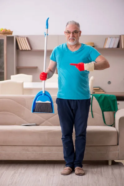 Старий прибирає будинок — стокове фото