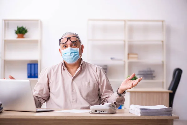 Ancien employé masculin travaillant sur le lieu de travail pendant la pandémie — Photo