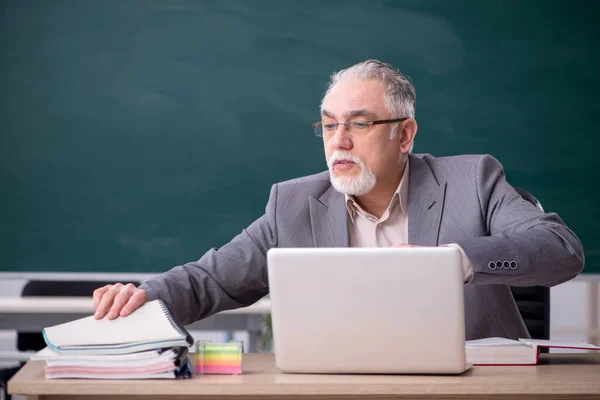 Oude mannelijke leraar voor schoolbord — Stockfoto