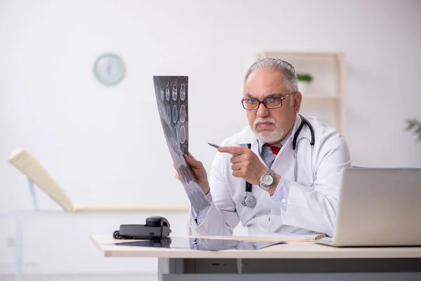 Gammal manlig röntgenläkare som arbetar på kliniken — Stockfoto