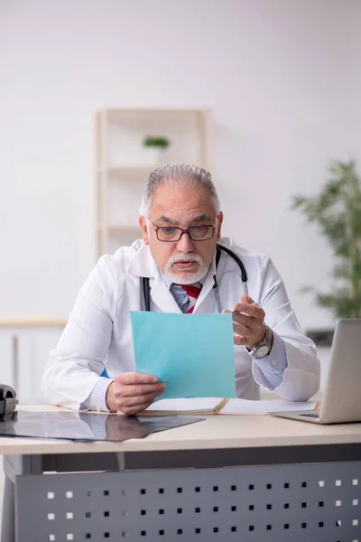 Velho médico do sexo masculino trabalhando na clínica — Fotografia de Stock