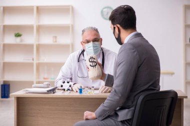 Genç işadamı aşı danışmanıyla yaşlı doktoru ziyaret ediyor.