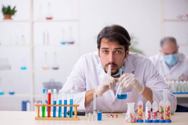 Laboratuvarda uyuşturucu sentezi konseptinde iki erkek kimyager.