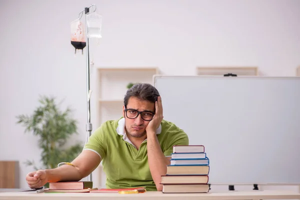 Young sick male teacher student in blood transfusion concept — Stock Photo, Image