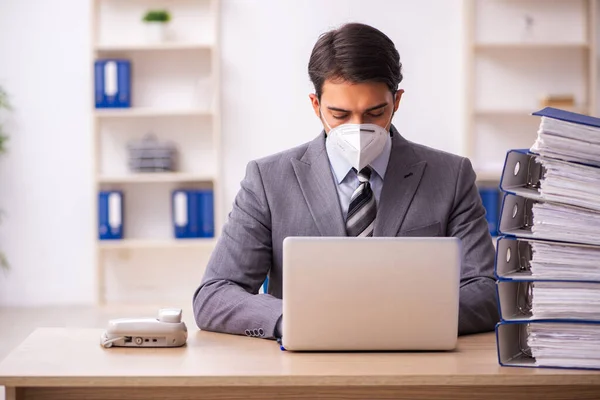 Jovem trabalhador do sexo masculino que trabalha no local de trabalho durante a pandemia — Fotografia de Stock