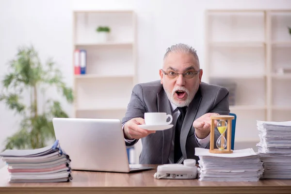 Velho funcionário do sexo masculino bebendo café durante o intervalo — Fotografia de Stock
