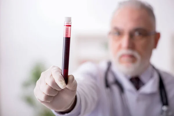 Gammal manlig läkare hematolog arbetar på kliniken — Stockfoto
