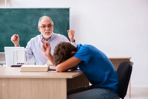 Oude mannelijke leraar en schooljongen in de klas — Stockfoto