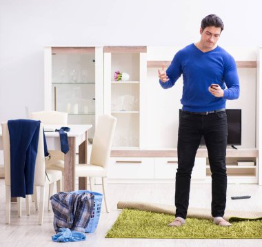 Genç adam çamaşırhane için kirli çamaşır topluyor.