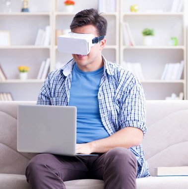 Evde sanal gerçeklik gözlükleriyle serbest çalışan bir öğrenci.
