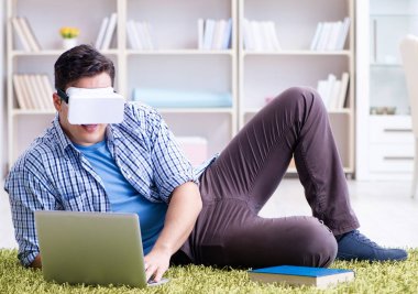 Evde sanal gerçeklik gözlükleriyle serbest çalışan bir öğrenci.