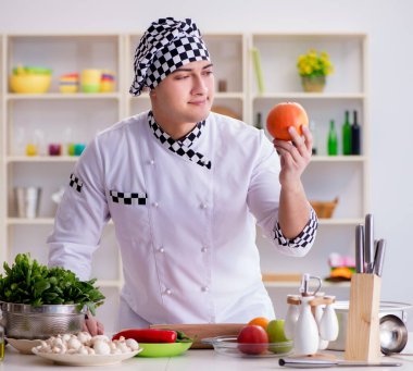 Genç aşçı mutfakta çalışıyor.