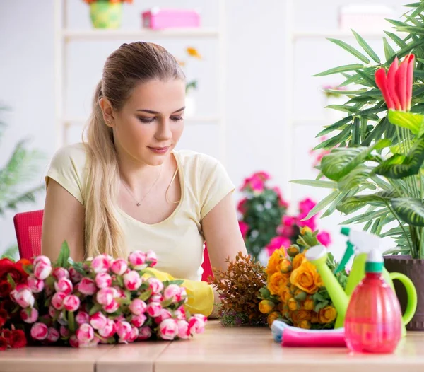 Mujer joven regando plantas en su jardín — Foto de Stock