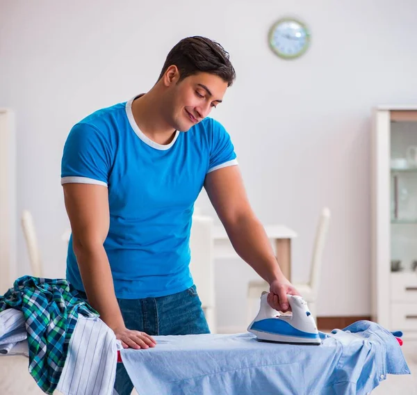 Man husband ironing at home helping his wife — Stock Photo, Image