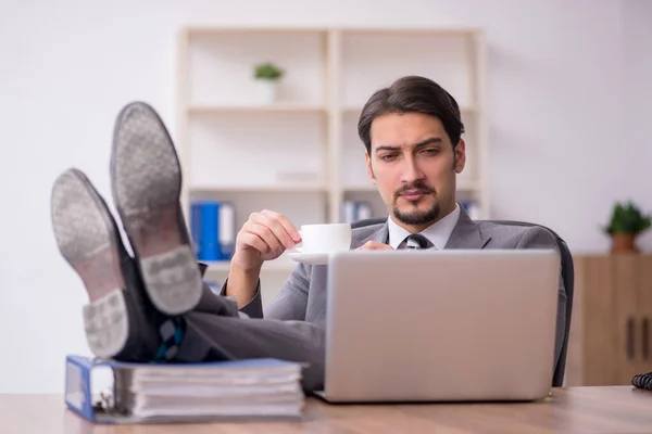 Joven empleado masculino bebiendo café durante el descanso — Foto de Stock