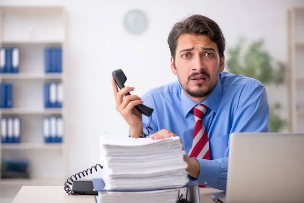 Jovem funcionário masculino infeliz com excesso de trabalho no escritório — Fotografia de Stock