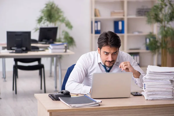 Joven empleado masculino descontento con el trabajo excesivo en la oficina — Foto de Stock