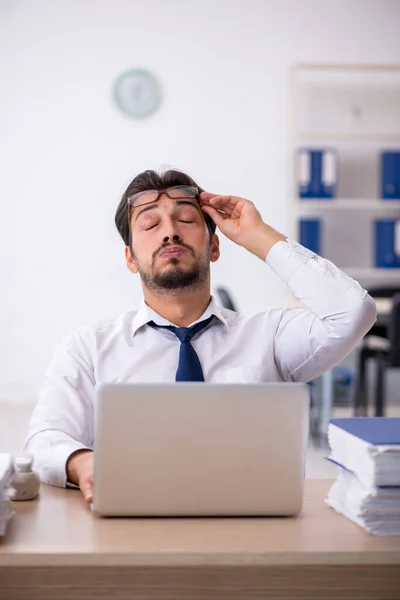 Jovem funcionário masculino infeliz com excesso de trabalho no escritório — Fotografia de Stock