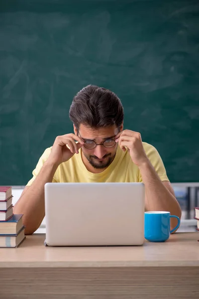 Giovane studente maschio che si prepara per gli esami in classe — Foto Stock