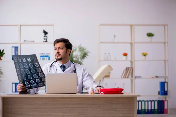 Ung manlig röntgenläkare som arbetar på kliniken — Stockfoto