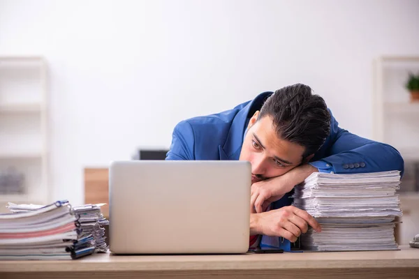 Jovem trabalhador masculino infeliz com excesso de trabalho no local de trabalho — Fotografia de Stock