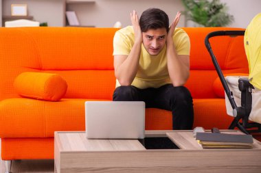 Genç adam evde yeni doğan çocuğa bakıyor.