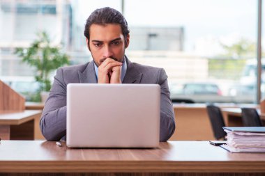 Ofiste çalışan genç bir erkek.