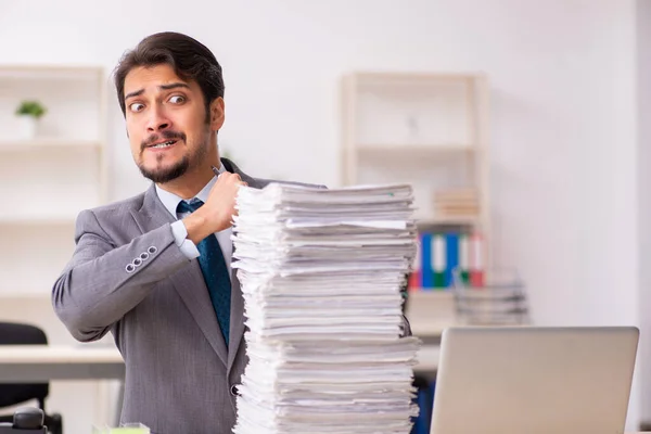 Giovane dipendente maschio infelice con un lavoro eccessivo in ufficio — Foto Stock