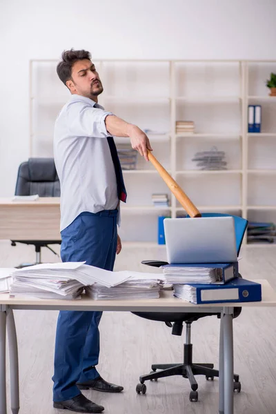 Joven empleado masculino descontento con el trabajo excesivo en la oficina — Foto de Stock