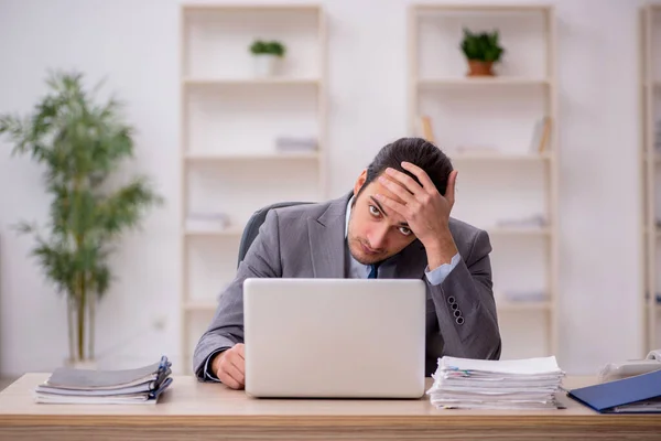 Junge männliche Angestellte unzufrieden mit exzessiver Arbeit im Büro — Stockfoto