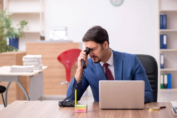 Jeune employé masculin assis sur le lieu de travail — Photo