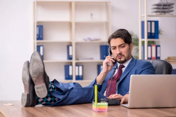 Empleado joven sentado en el lugar de trabajo —  Fotos de Stock