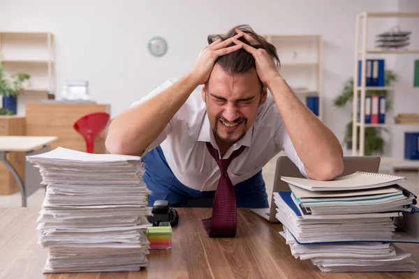 Jeune employé masculin et trop de travail au bureau — Photo