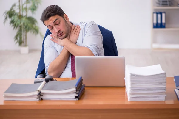 Jovem empresário e muito trabalho no escritório — Fotografia de Stock