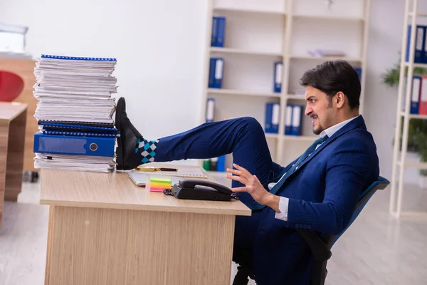 Joven empleado masculino y demasiado trabajo en la oficina —  Fotos de Stock