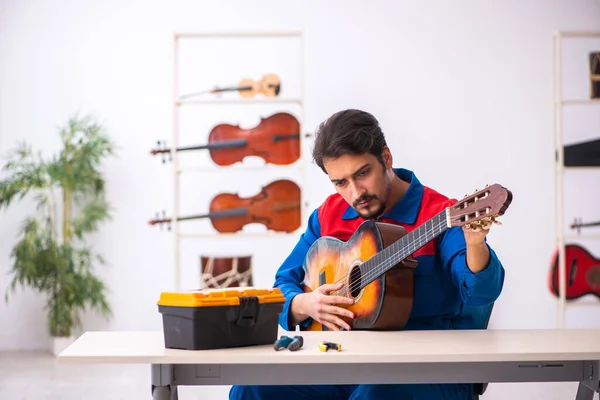 職場で楽器を修理する若い男性 — ストック写真