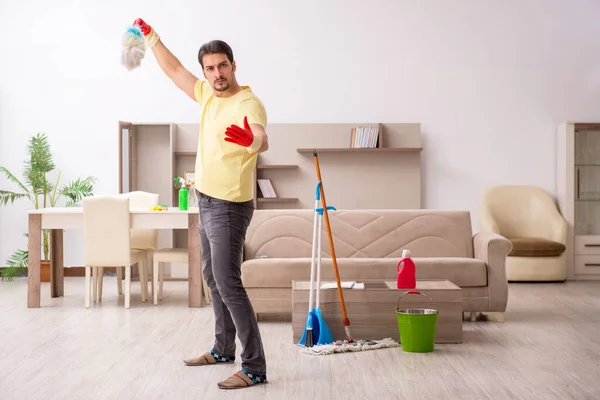 Jonge mannelijke aannemer schoonmaken van het huis — Stockfoto