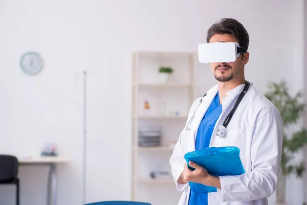 Joven doctor con gafas virtuales en la clínica —  Fotos de Stock